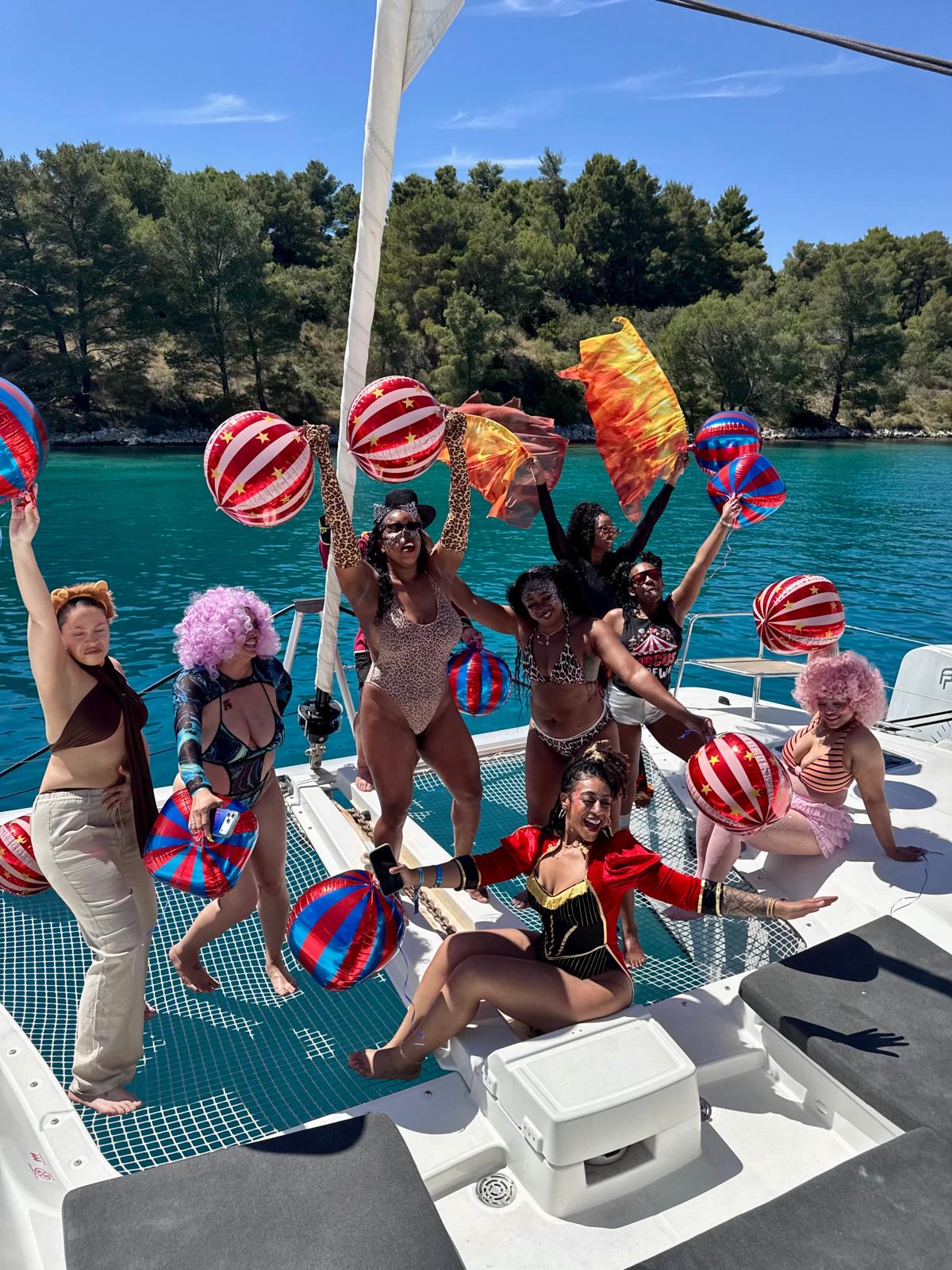 The group in circus costumes celebrating on a catamaran in Croatia