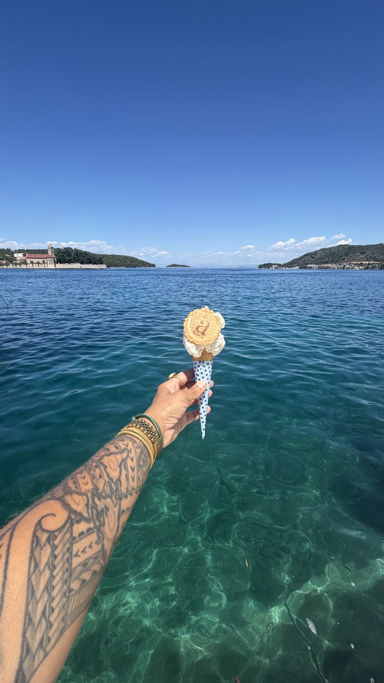 Holding a flower over the clear blue water in Croatia