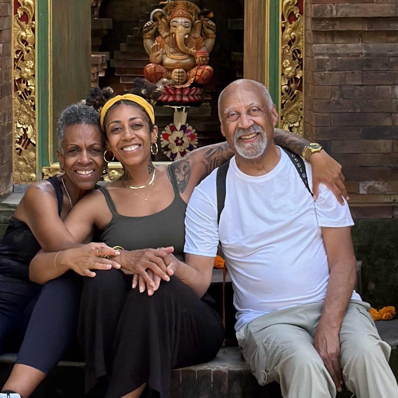 Ashleigh Bing sitting with her parents at a temple in Bali
