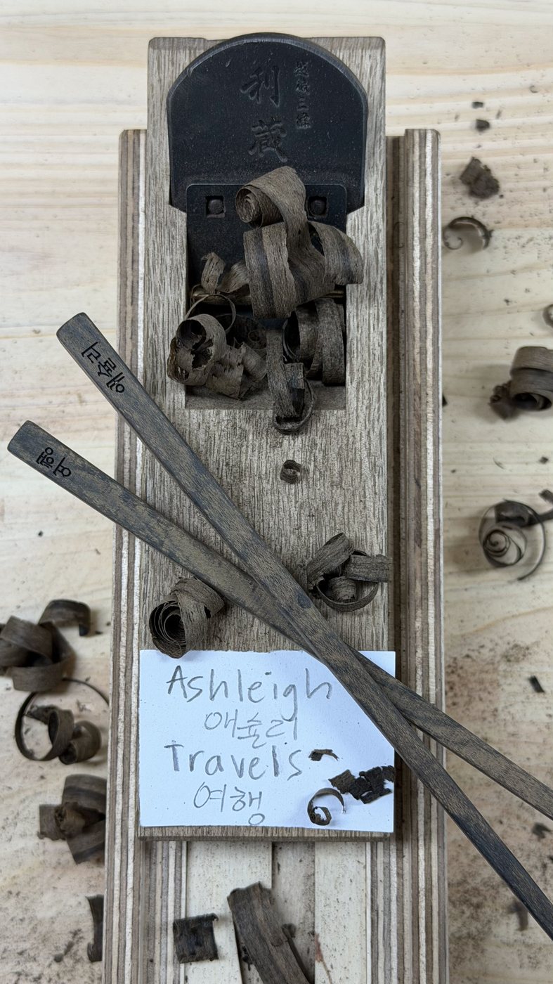 A handmade wooden stamp reading Ashleigh Bing Travels