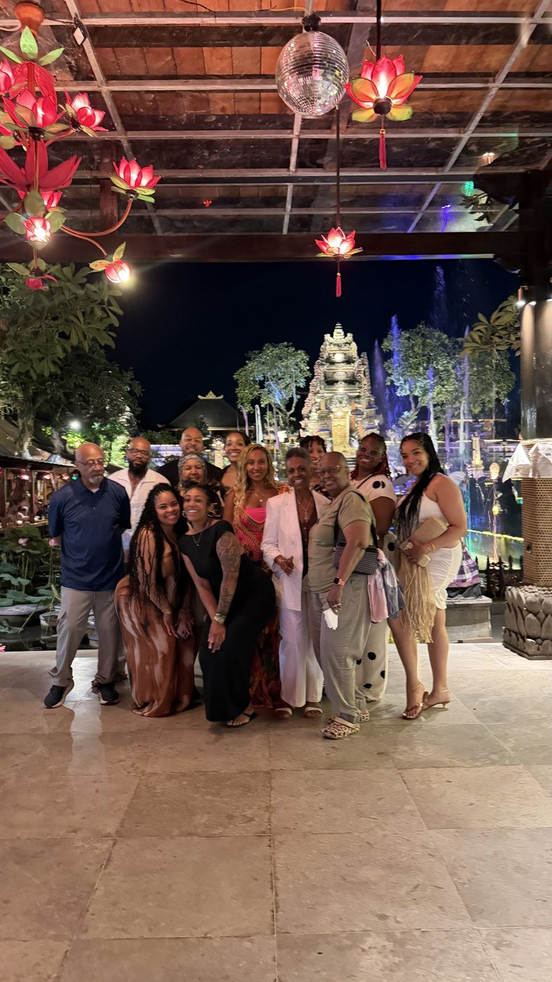 The group dressed up at night in front of a lit-up temple in Bali