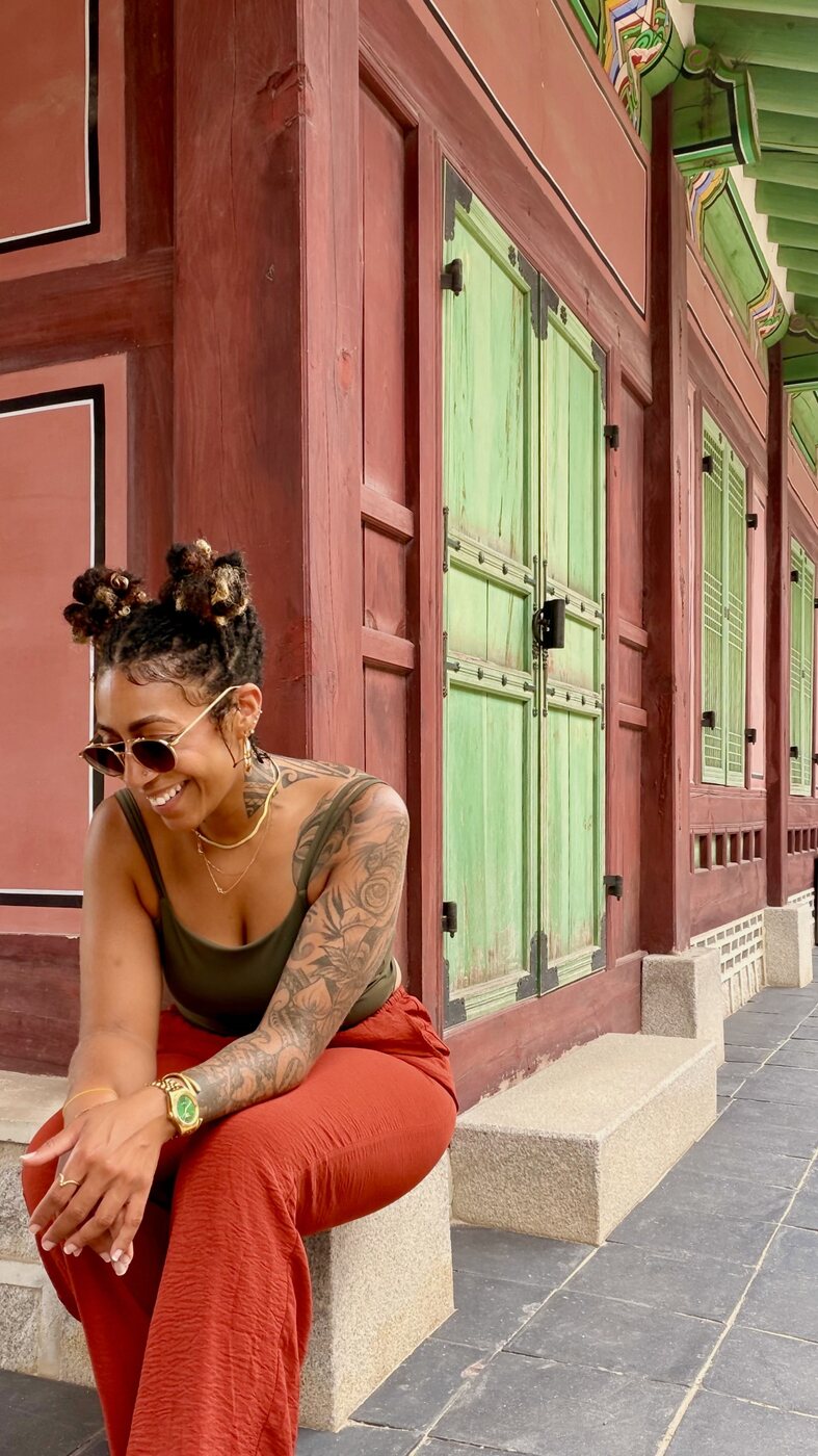 Ashleigh Bing sitting in front of colorful traditional Korean doors